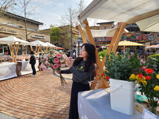 신세계사이먼 여주 프리미엄 아웃렛 야외 공간에서 진행되는 스프링 플라워 마켓에서 모델이 포즈를 취하고 있다. 신세계사이먼 제공